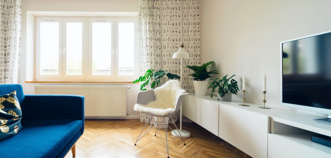 Intérieur de l'appartement, pièce salle a mange avec canapé bleu et sol en parquet