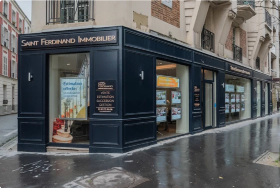 Devanture de l'agence immobilière, bâtiment noir dans une rue.